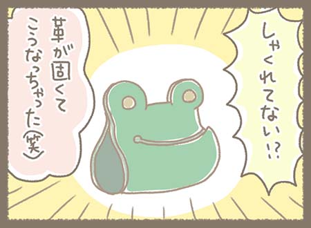 試作品として作られた緑色のカエル型コードホルダーが大きく描かれ、口元が前に突き出したしゃくれたような形になっていることをスタッフたちが面白がって確認している。
